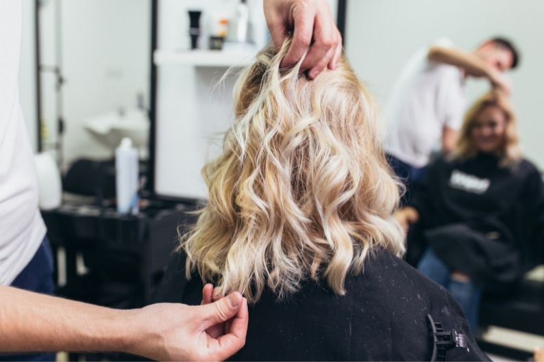 A female client comes in for her regular cut and style appointment at a beauty franchise.