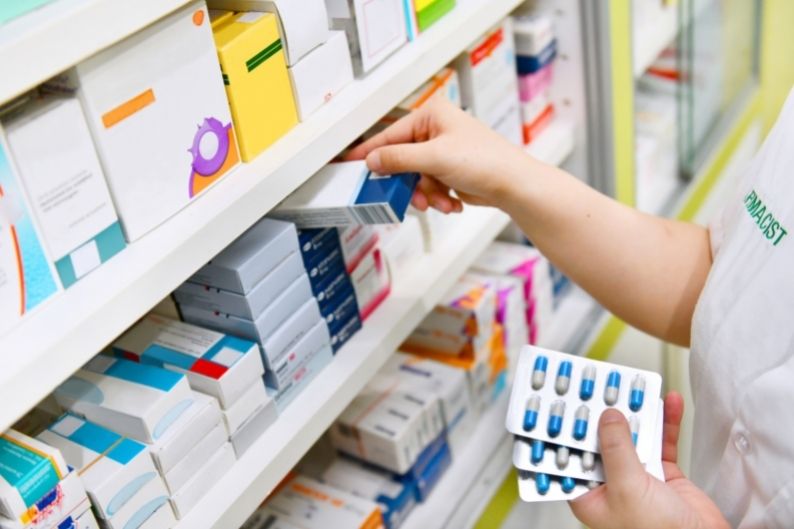 A pharmacy franchise employee restocks shelves.