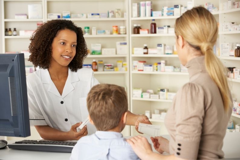 F123 Blog Photo Size (36).jpg A pharmacist discusses medications with clients.