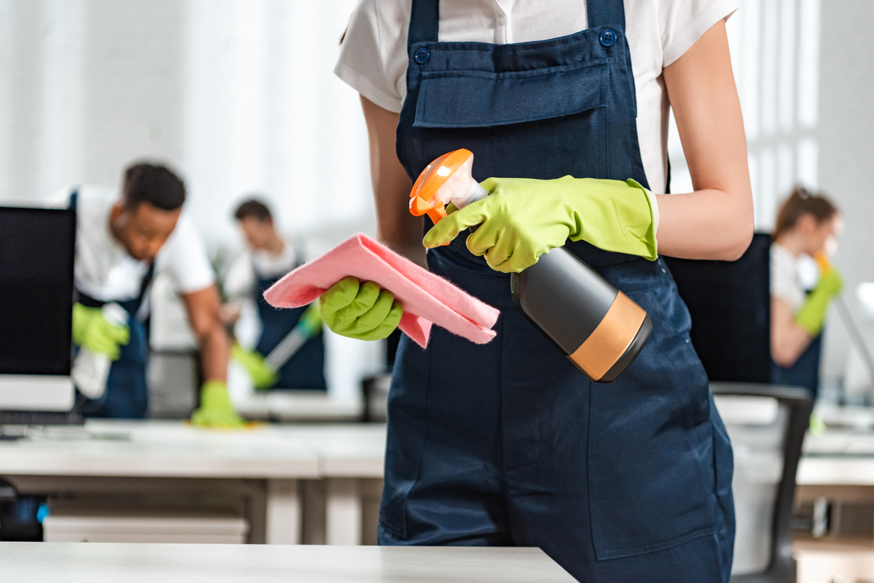 A team of cleaners from a cleaning franchise sanitizes an office space. 
