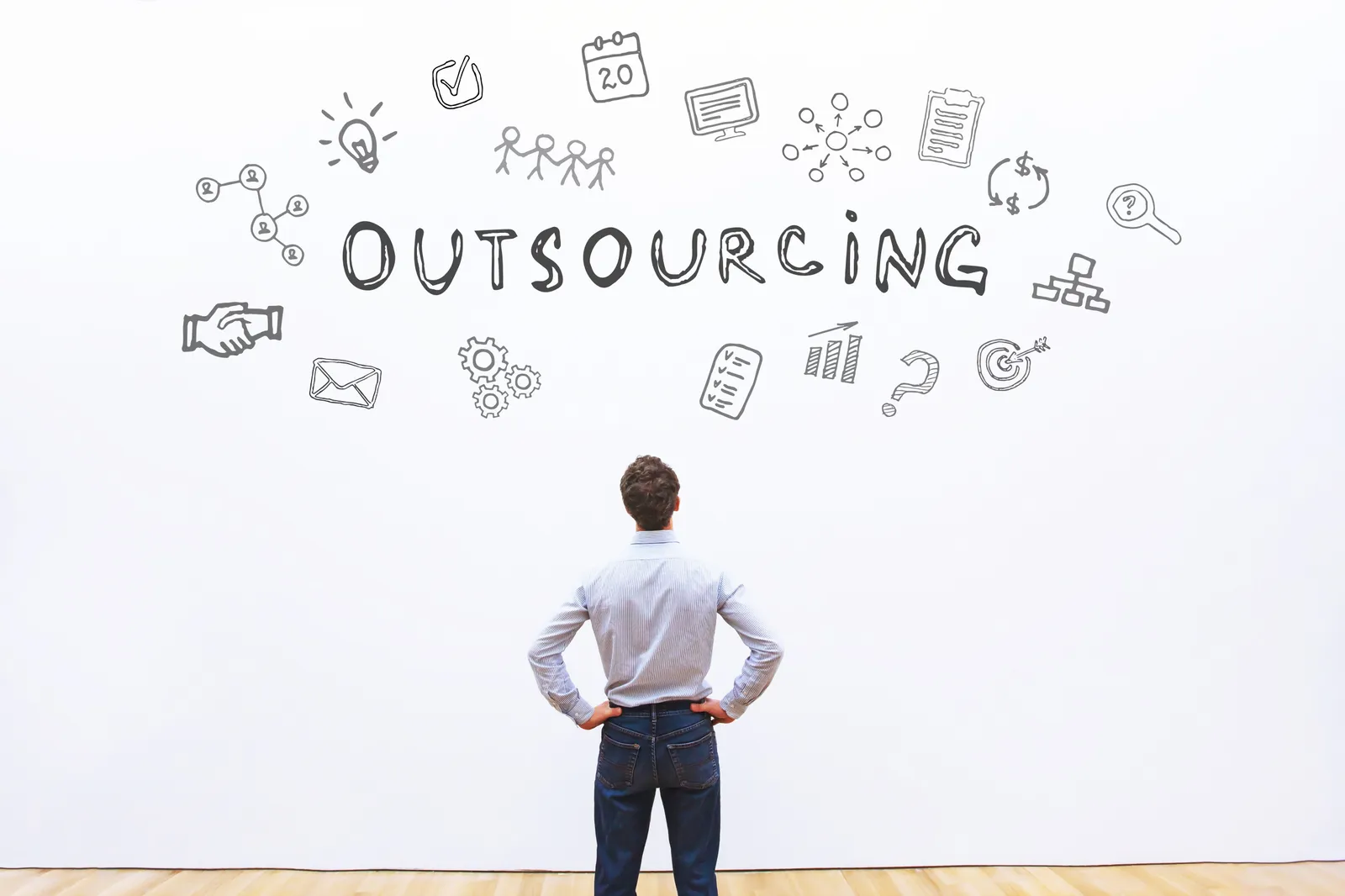 Uomo che guarda la parola "Outsourcing" con grafici.