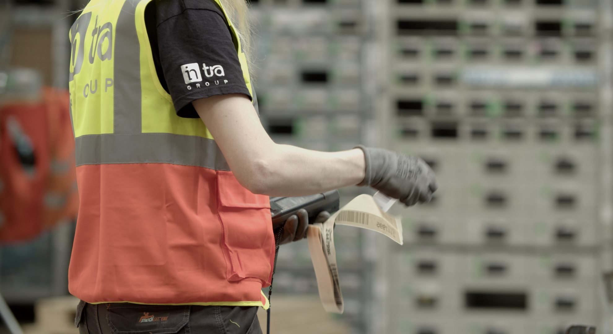 Un dipendente indossa un gilet giallo e arancione con un logo.