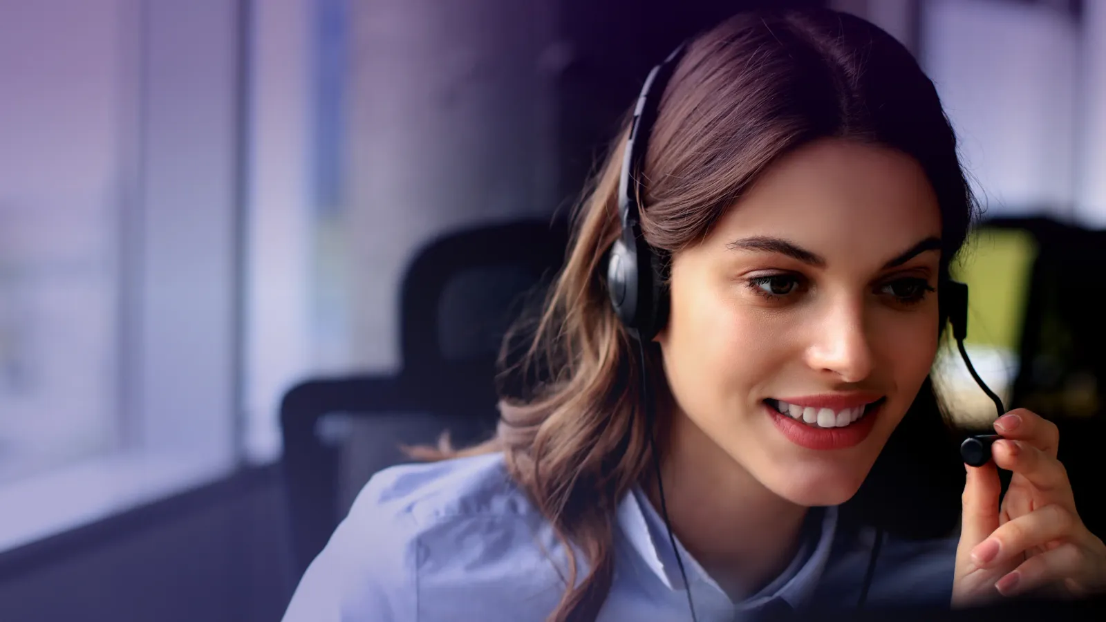 Operatrice del call center sorridente che indossa una cuffia.
