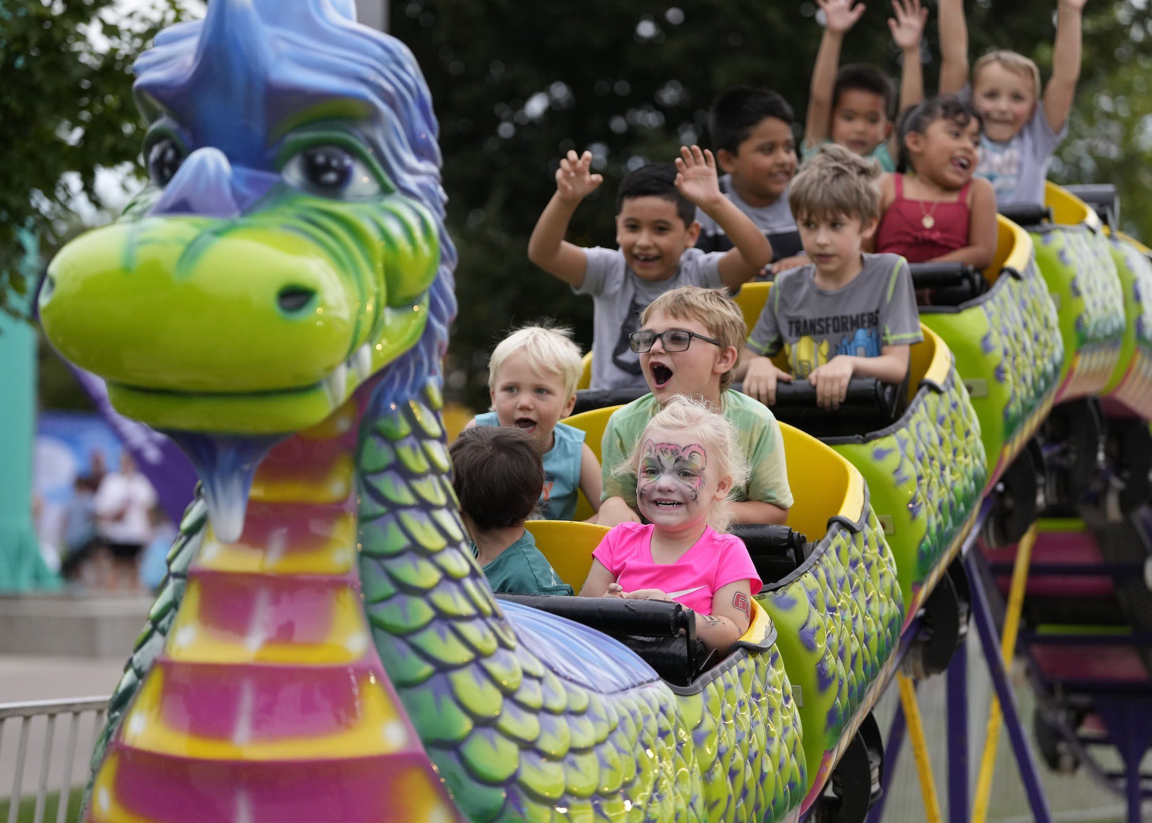 Little kids on Thrill rides waving arms