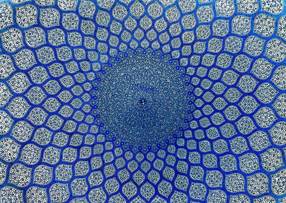 Intricate, symmetrical blue and white Persian tile dome pattern.