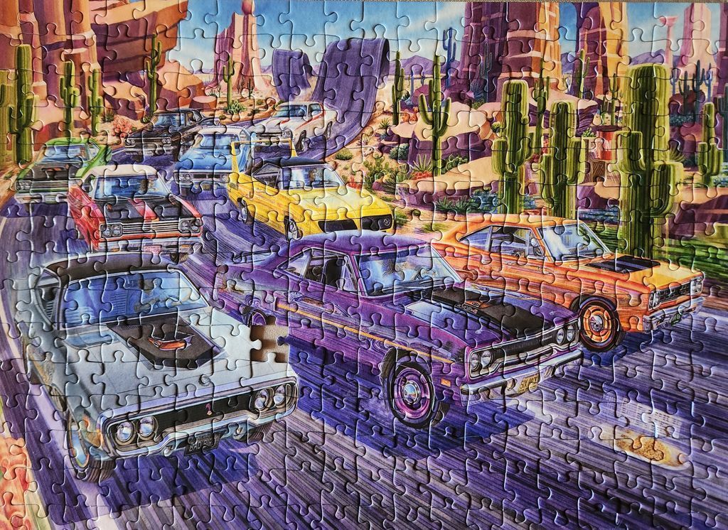 Illustration of vintage muscle cars racing on a desert road through cactus-filled rock formations.