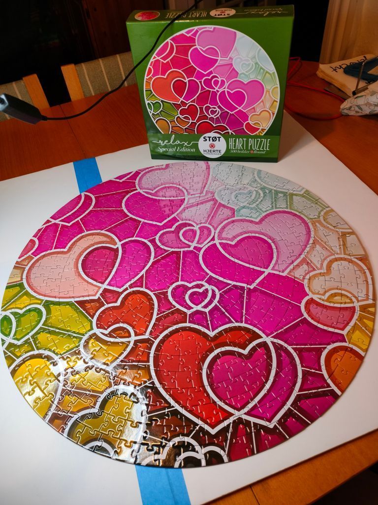 A round circular design featuring numerous overlapping hearts in a vibrant stained glass style.
