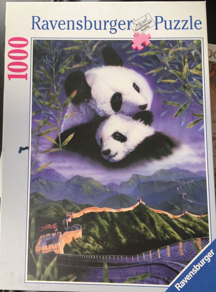 Two giant pandas resting above a misty landscape featuring the Great Wall of China.