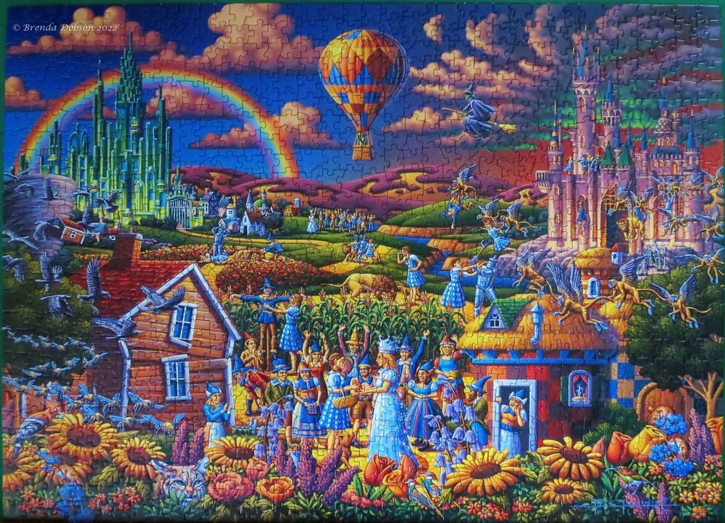 A vibrant, whimsical fantasy illustration of the Land of Oz featuring castles, iconic characters, and a hot air balloon.