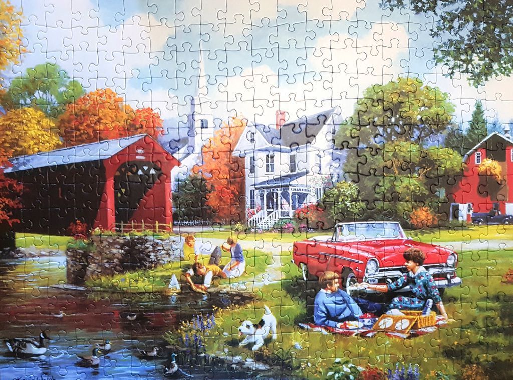A nostalgic rural scene featuring a covered bridge, a classic red convertible, and a family picnicking by a stream.