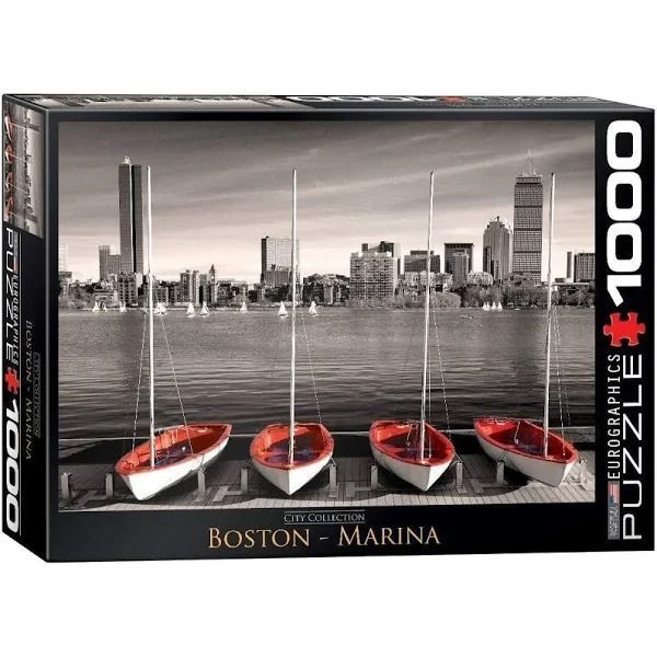Four red and white sailboats moored at a dock with the Boston skyline in the background.