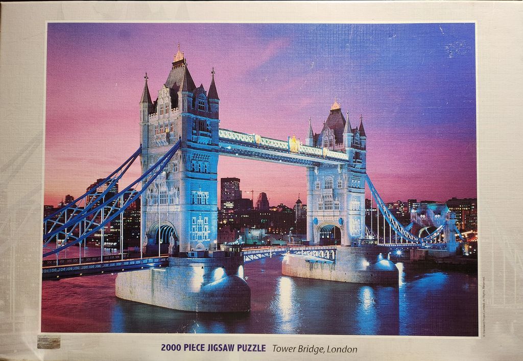 Tower Bridge in London illuminated at twilight with a vibrant purple and orange sunset sky.
