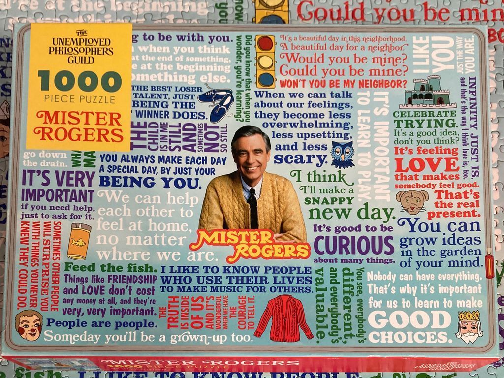 Mister Rogers surrounded by inspirational quotes and iconic symbols from his television program.