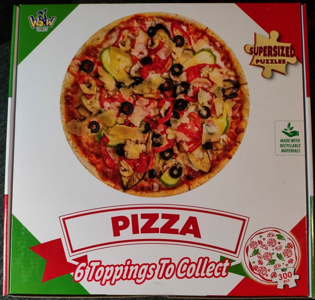 A close-up photograph of a vegetarian pizza featuring tomato sauce, black olives, zucchini slices, and cheese flakes.