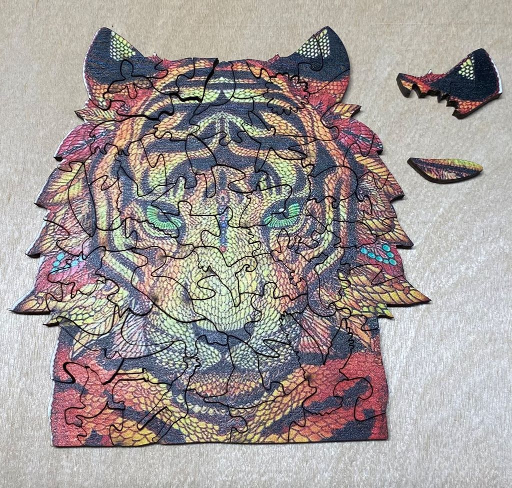 A stylized artistic illustration of a tiger's head featuring vibrant patterns and warm colors.