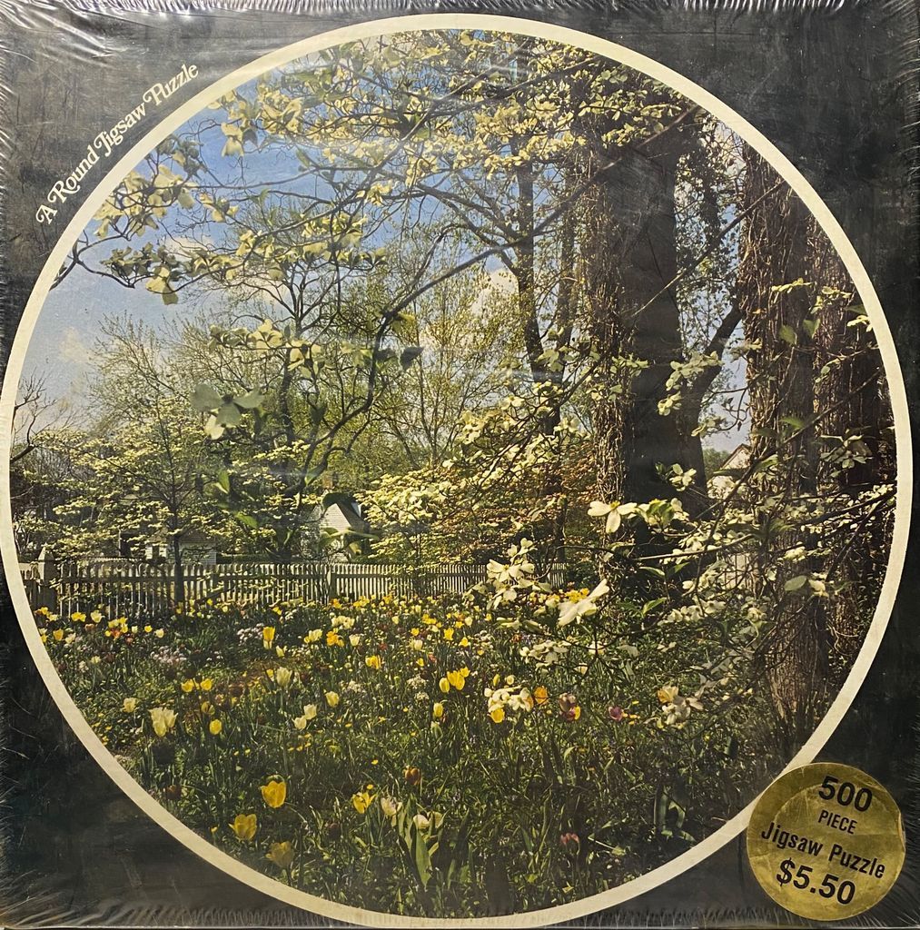 A circular image showing a blooming garden in spring with dogwood trees and colorful tulips.