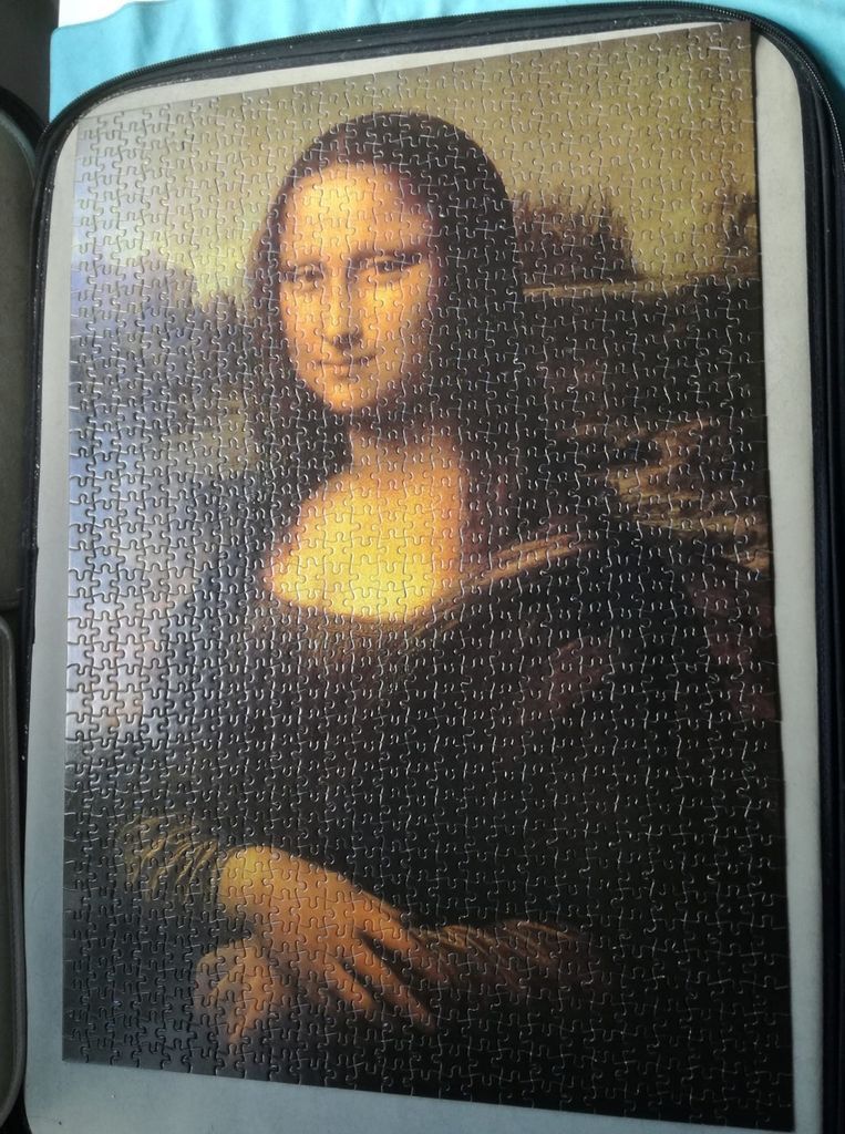 The Mona Lisa portrait painting against a dark, hazy landscape background.