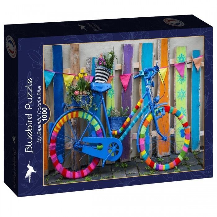 A blue bicycle decorated with multi-colored yarn wraps parked against a multi-colored picket fence.