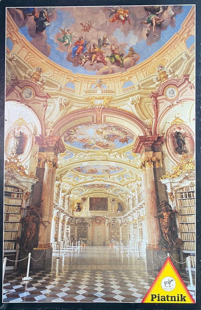 Ornate interior of an 18th-century library with elaborate frescoes on the arched ceilings.