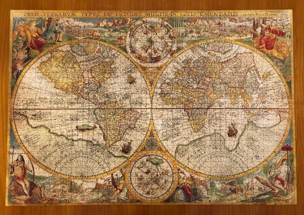 A vintage 16th-century style world map illustration featuring two large circular hemispheres and celestial diagrams.