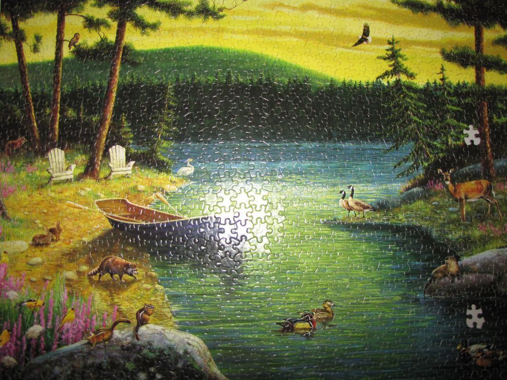A peaceful lakeside scene at sunset with a boat and various woodland animals.