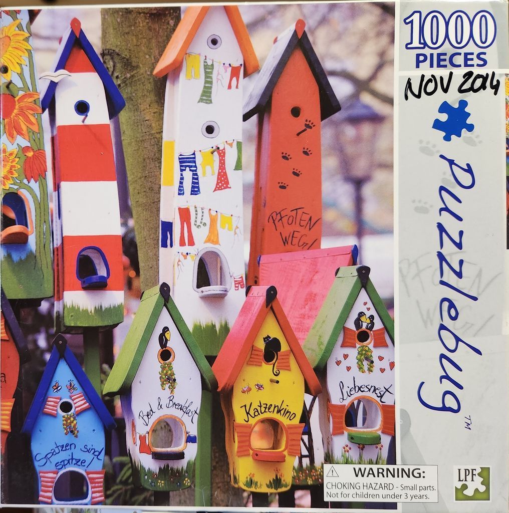 A collection of brightly painted, whimsical birdhouses in a garden setting.