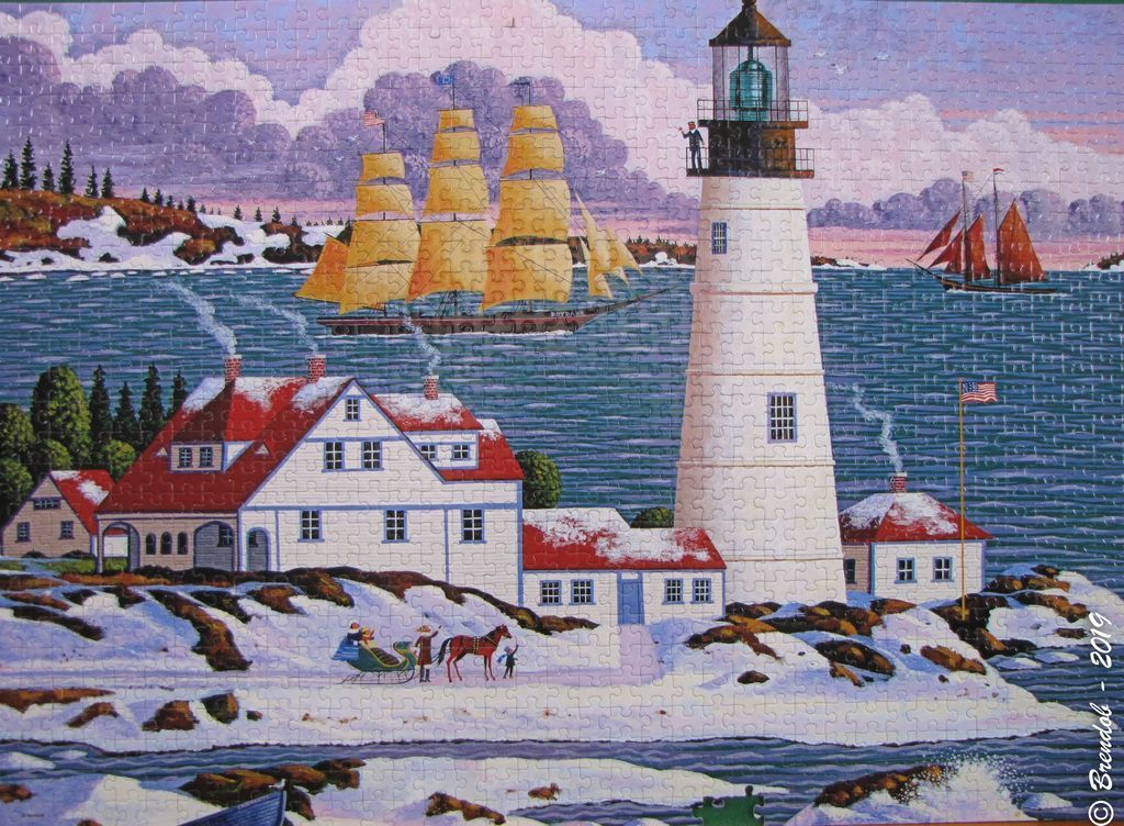 A wintry coastal scene featuring a tall white lighthouse, a large sailing ship, and a house covered in snow.