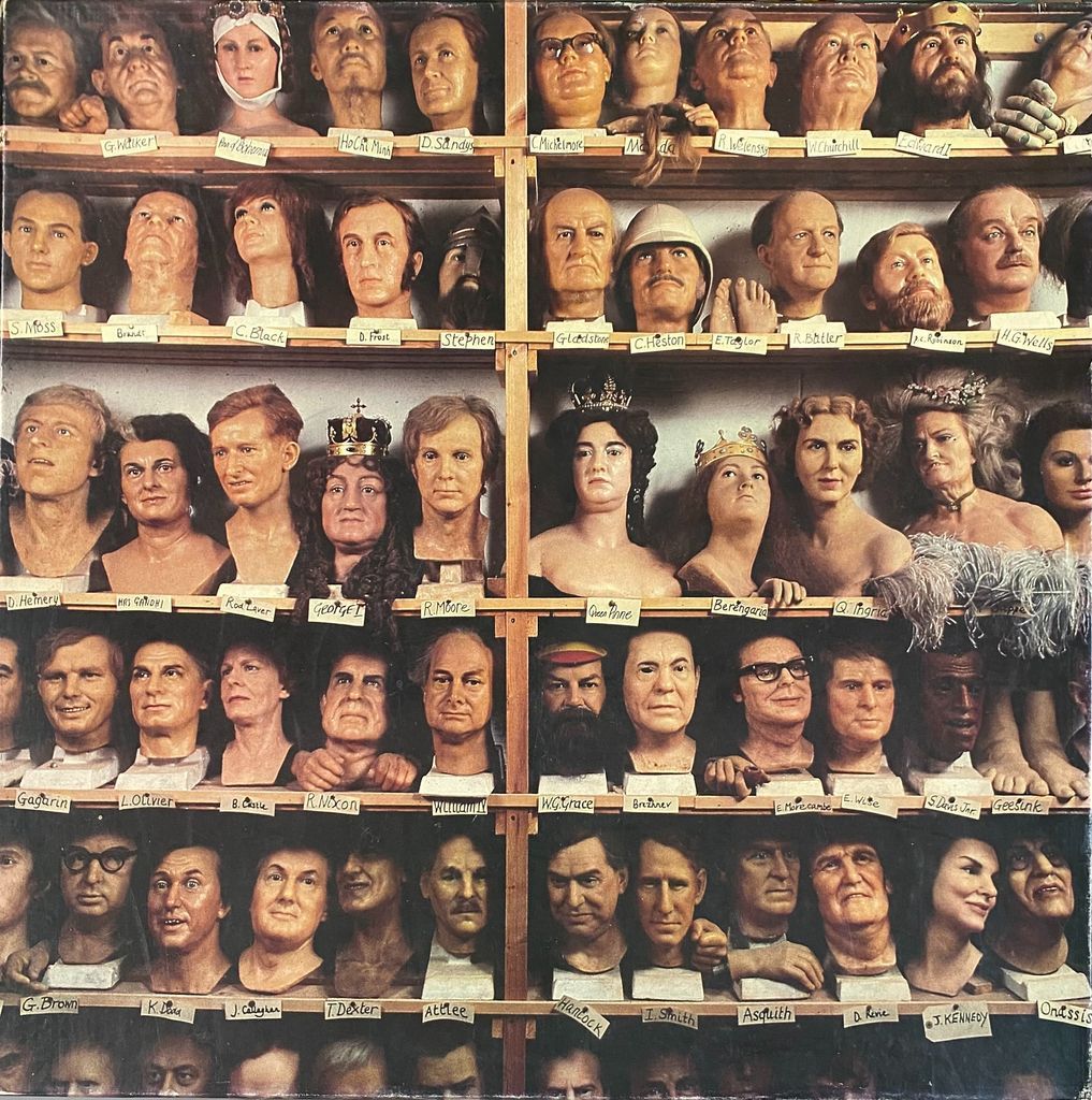 A collection of historical and celebrity waxwork heads arranged on shelves in a studio.