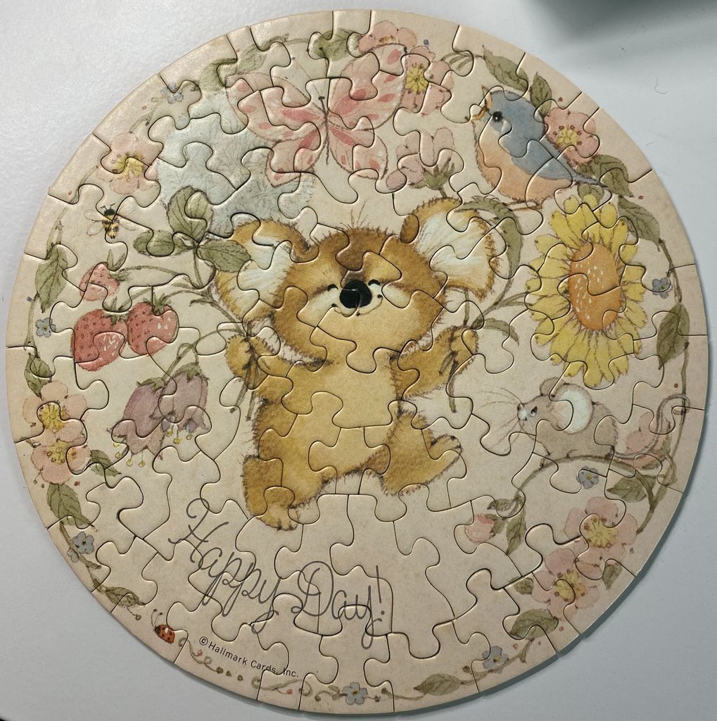 Round illustration of a cute koala surrounded by flowers, a bird, and a mouse with the words 'Happy Day!'