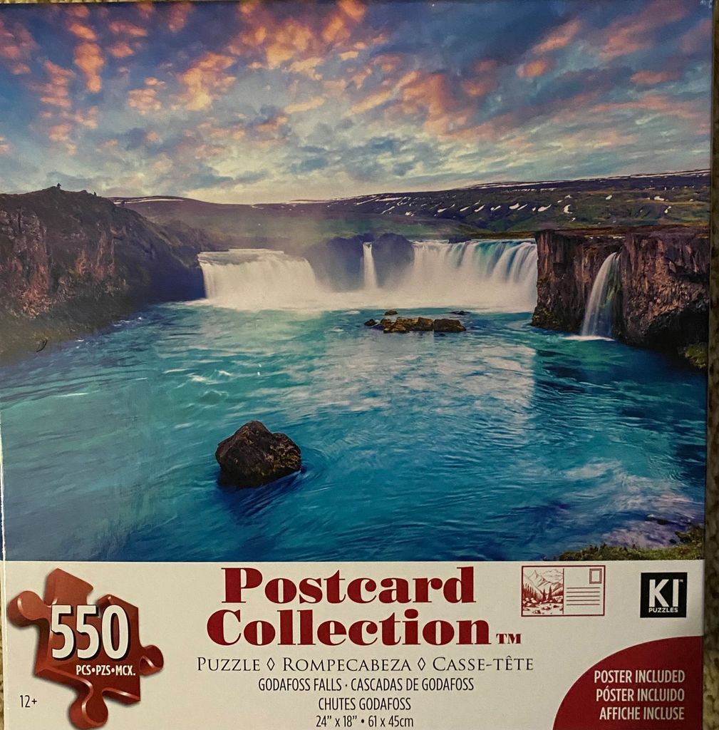 A panoramic landscape photograph of Goðafoss waterfall in Iceland under a vibrant sunset sky.