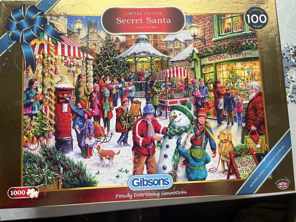 Illustration of a busy, snow-covered village square filled with people and a snowman at Christmas.
