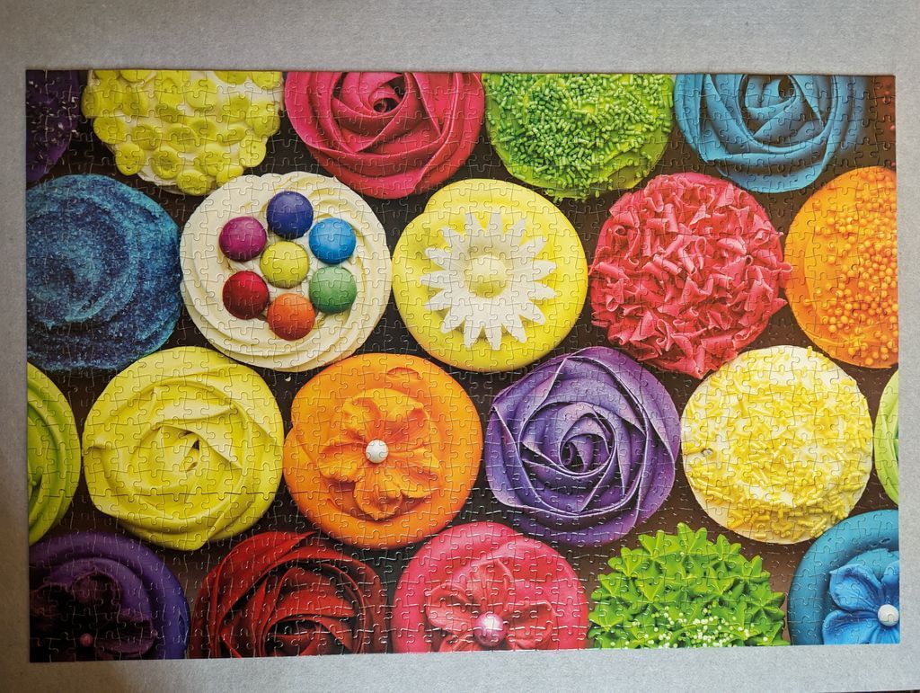 A top-down collection of colorful, artistically decorated cupcakes.