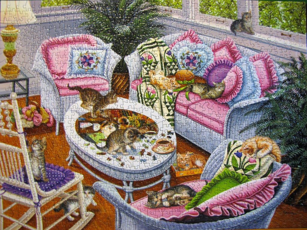 A cozy sunroom filled with white wicker furniture and numerous tabby kittens