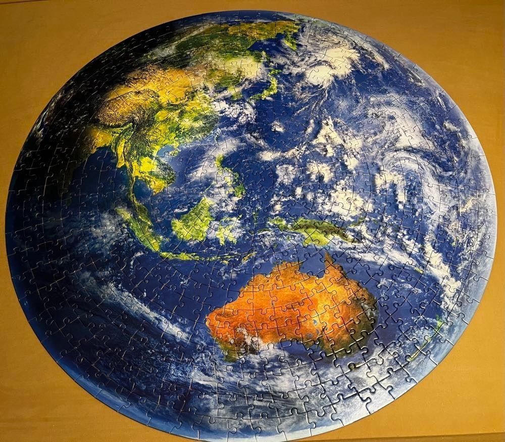 A circular satellite view of the Earth featuring Southeast Asia, Australia, and the Pacific Ocean.