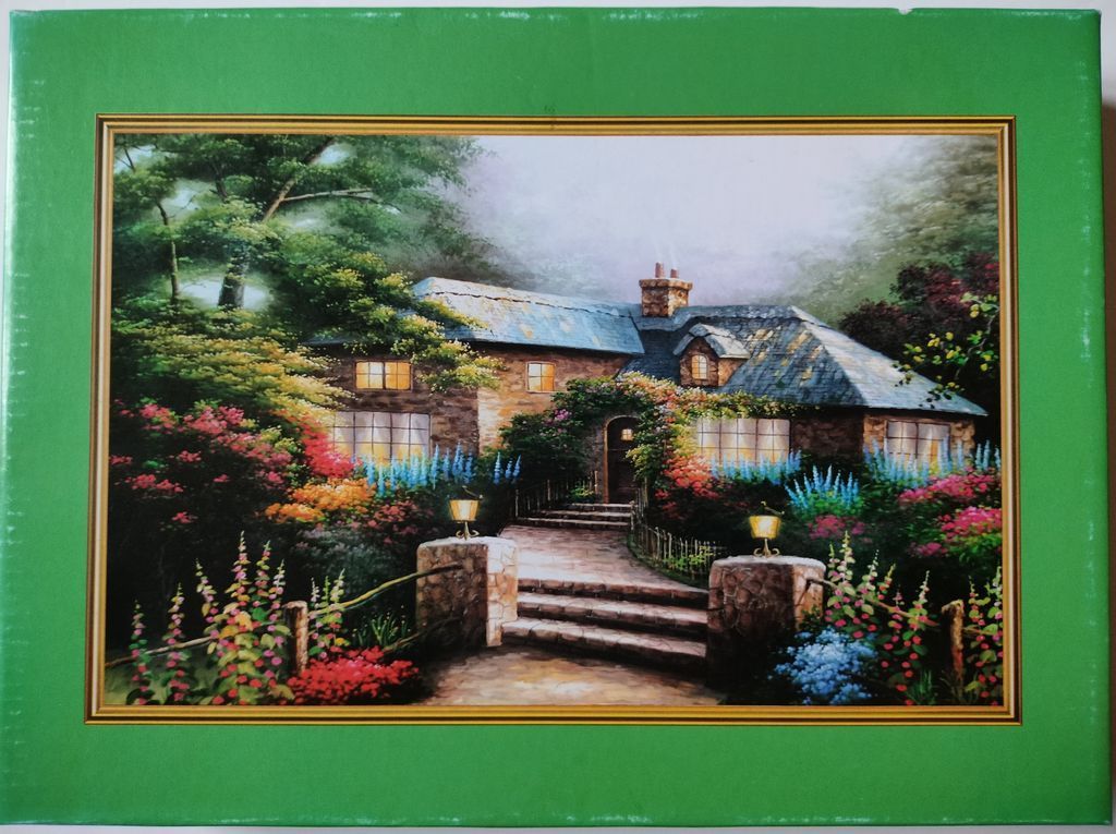 A cozy stone cottage at dusk with glowing windows and a vibrant, flower-filled garden in front.