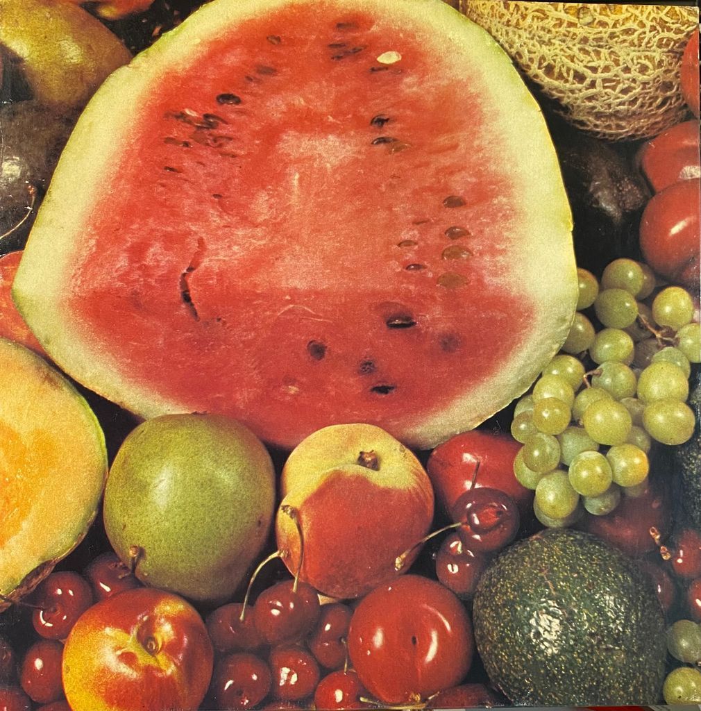 A close-up, high-angle view of a bountiful variety of fresh fruits including watermelon, grapes, peaches, and cherries.