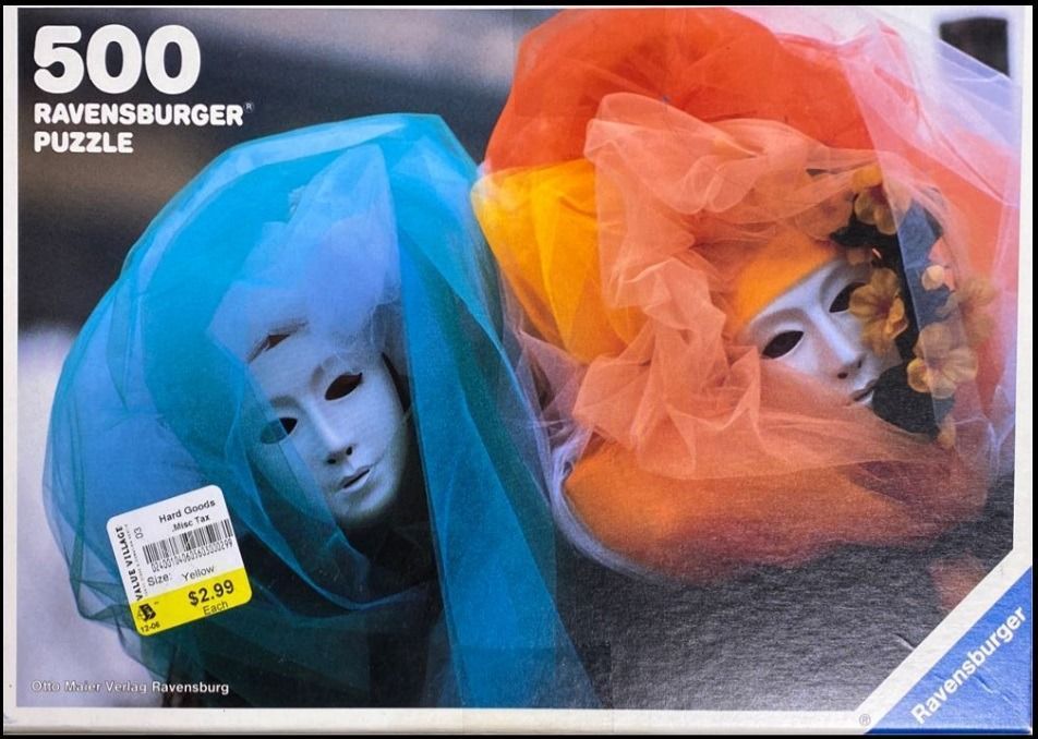 Two theatrical masks draped in vibrant blue and orange tulle fabric.