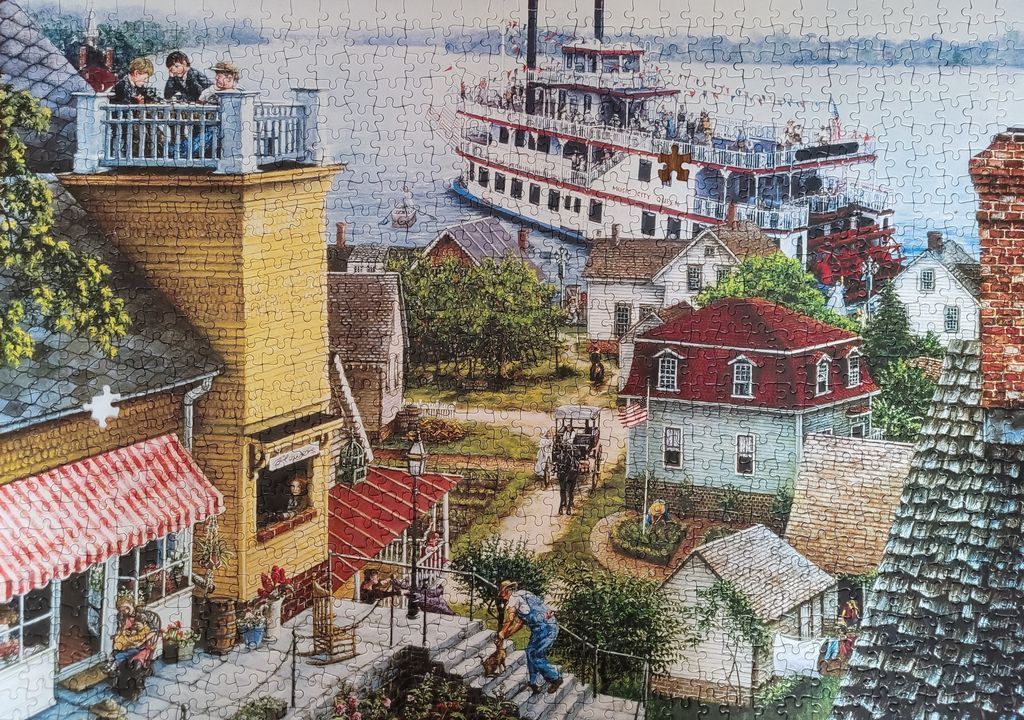 A nostalgic riverside town scene featuring a large paddlewheel riverboat and historic buildings.