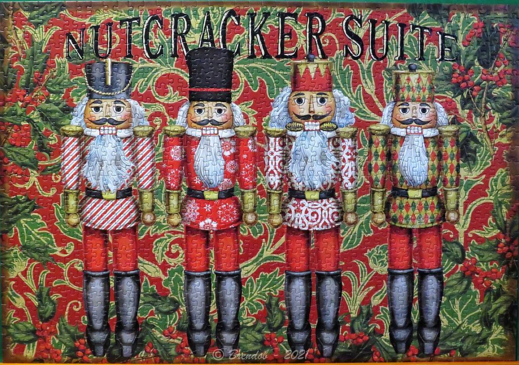 Four distinct, colorful nutcracker figurines arranged in a line against a festive holly and berry background.
