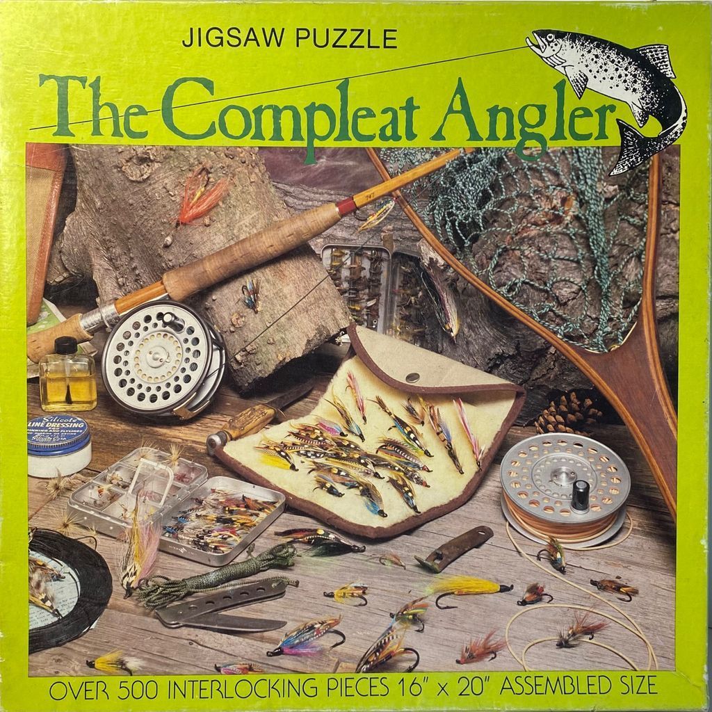 A still-life arrangement of vintage fly-fishing gear including rods, reels, nets, and a collection of artificial flies.