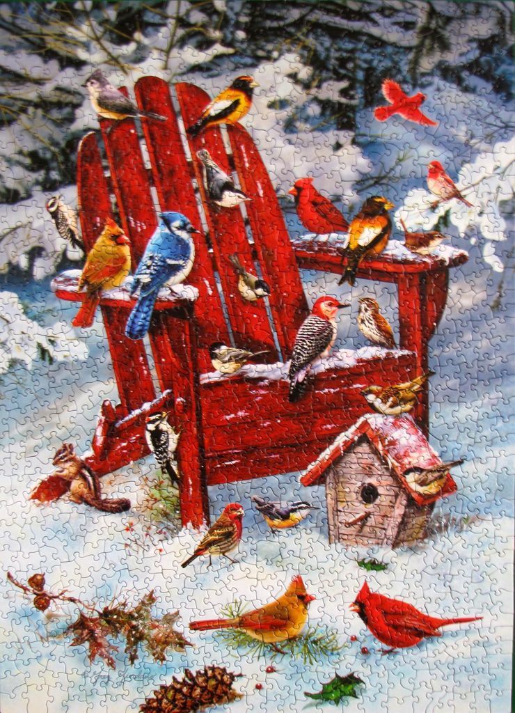 A vibrant red Adirondack chair in a snowy forest surrounded by many colorful birds