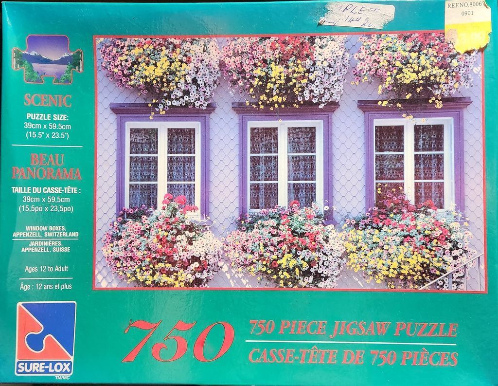 A house facade in Appenzell, Switzerland, with three windows overflowing with vibrant flowers.