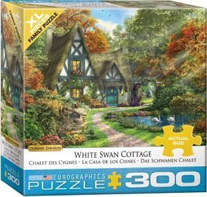 A charming thatched-roof cottage with a stone path leading to a pond with two white swans.
