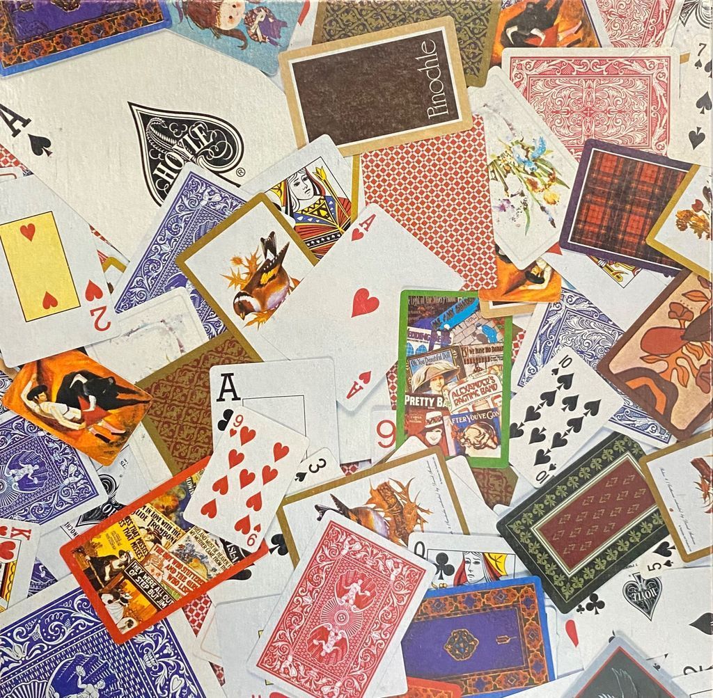 A chaotic, overlapping jumble of vintage and standard playing cards of various designs and back patterns.
