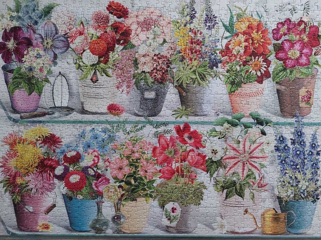 A collection of botanical-style bouquets arranged in rustic buckets on two garden shelves.