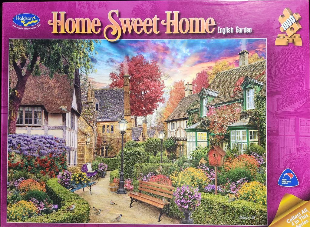 A peaceful English cottage garden with flowers, a wooden bench, and traditional stone houses at twilight.