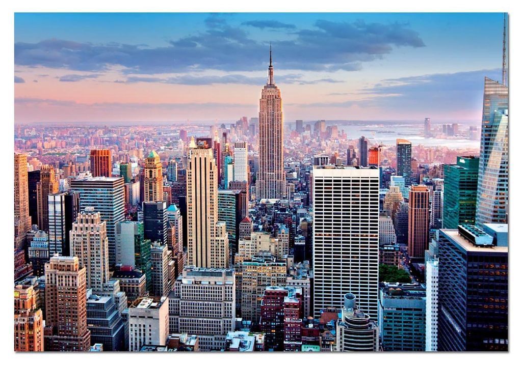 Aerial view of the New York City skyline at sunset with the Empire State Building as the central focal point.