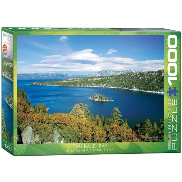 A panoramic landscape photograph of Emerald Bay at Lake Tahoe featuring a small island, deep blue water, and snow-capped moun