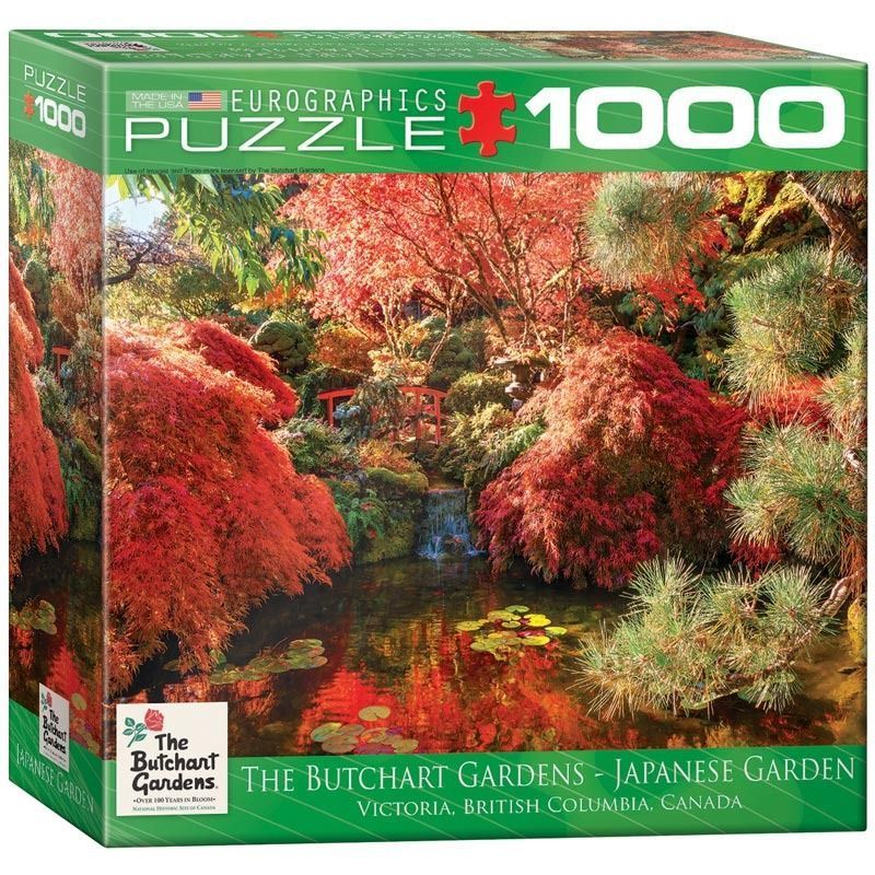A lush Japanese-style garden in autumn, featuring red maple trees, a small waterfall, and a pond with lily pads.