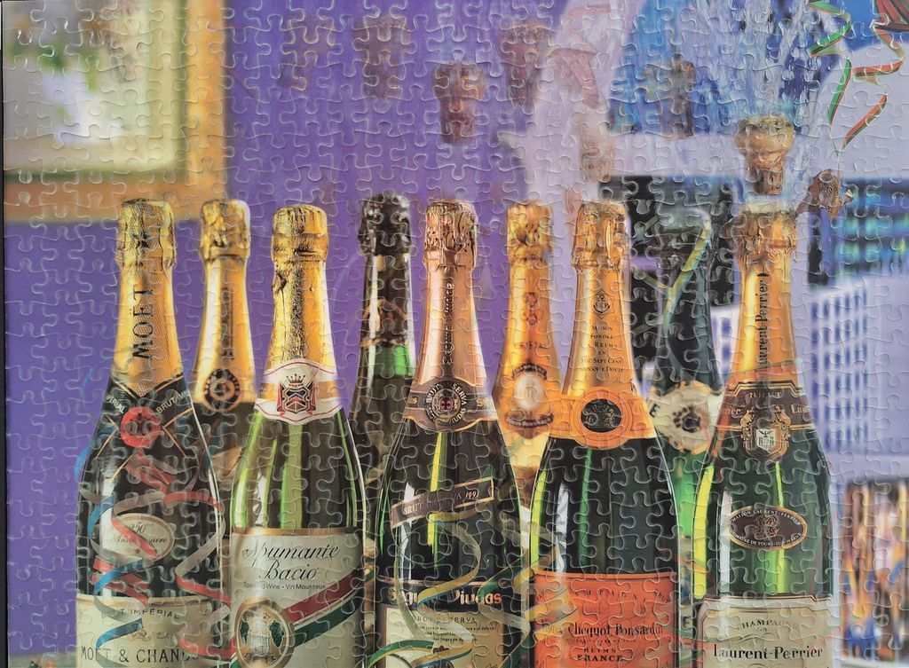A collection of various champagne and sparkling wine bottles arranged in front of a purple background.